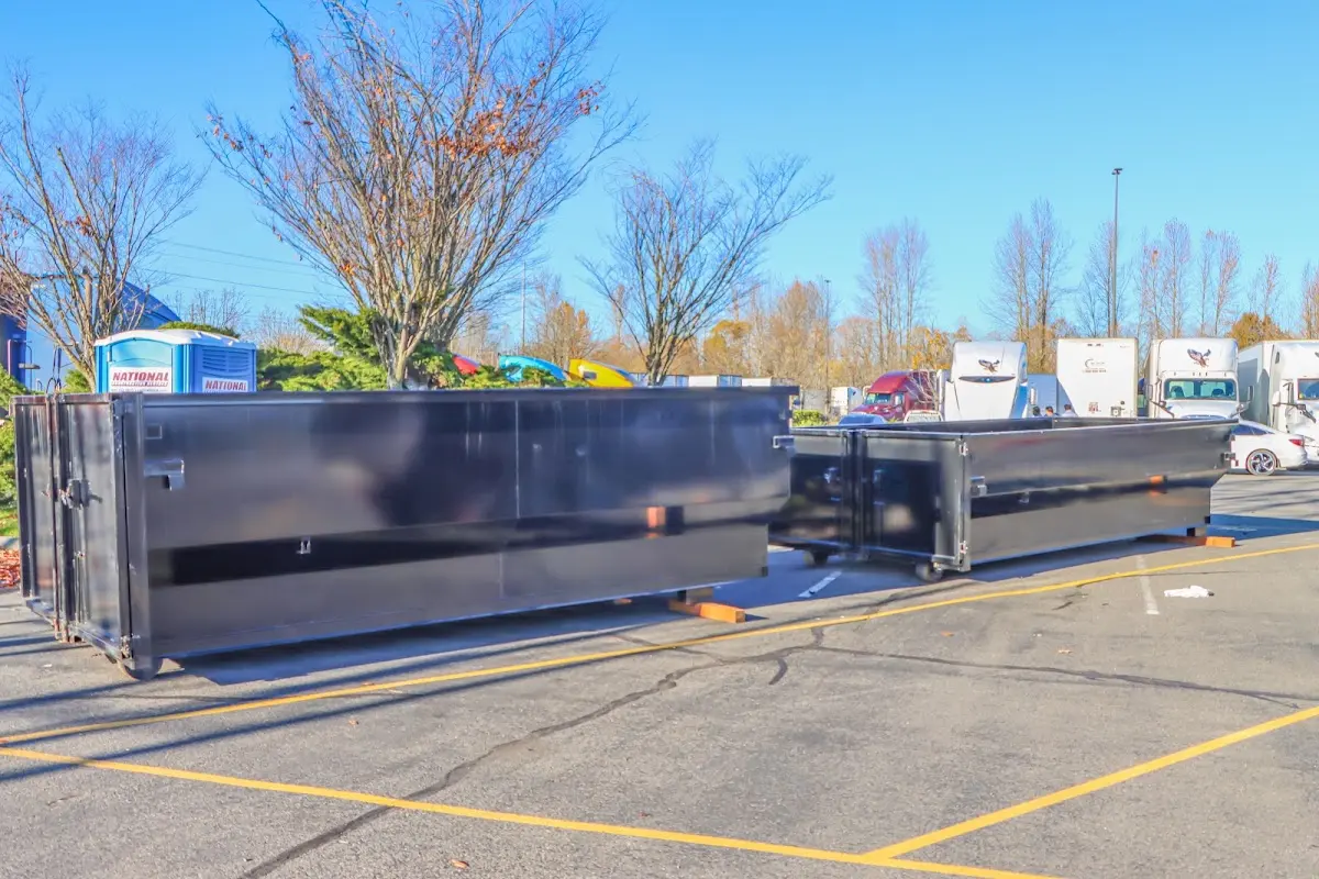 Professional dumpster rental service with roll-off container on residential driveway in Evergreen